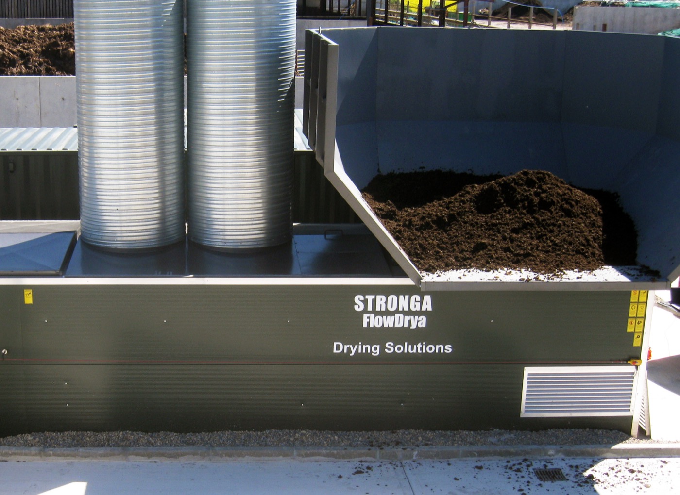 STRONGA FlowDrya unit with silver air ducts loading wet coffee grounds for drying